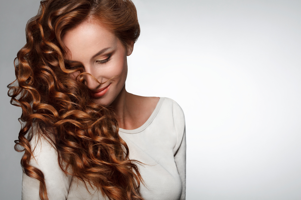 Red Hair. Woman with Beautiful Curly Hair