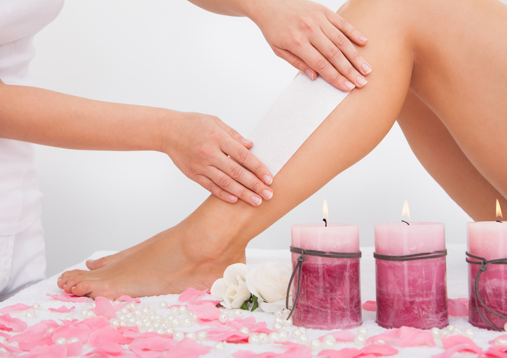 Beautician Waxing A Woman's Leg