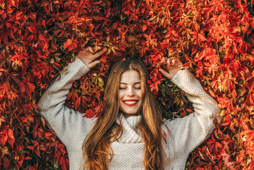 Young,Happy,Woman,Upon,A,Wall,Of,Red,Ivy,Leaves.