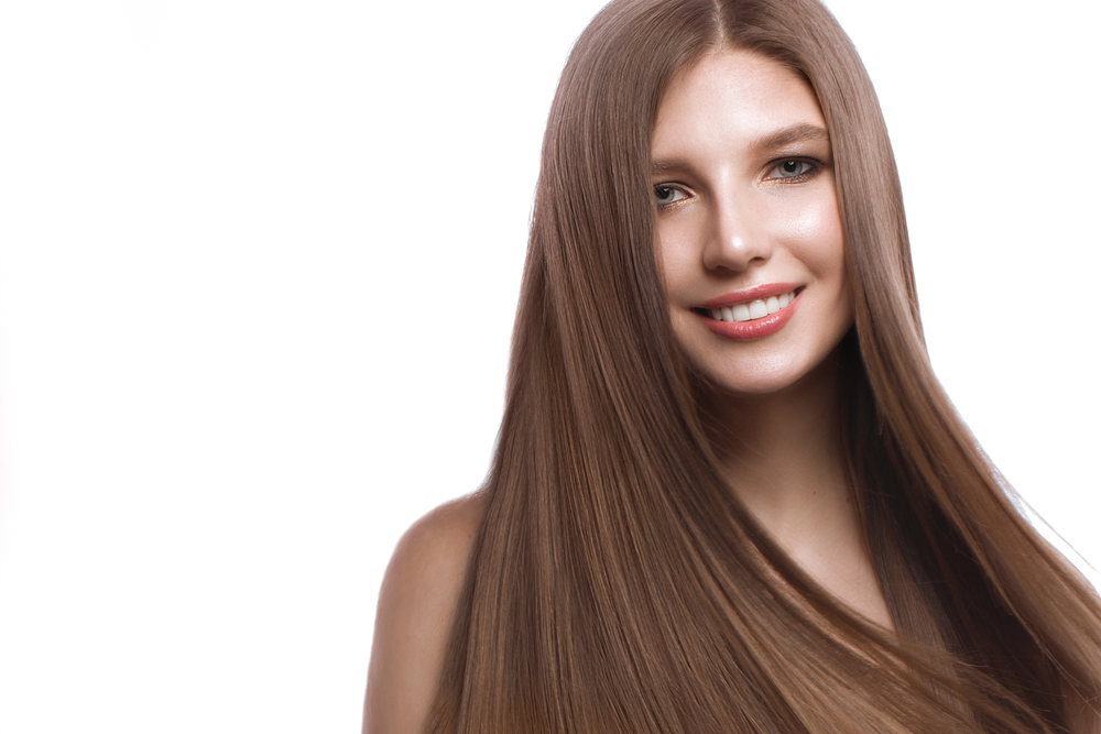 Woman with long, straight, glossy brown hair after keratin treatment